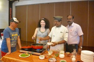 Multă lume m-a întrebat ce am mâncat în Kerala, India. Ce se poate mânca. Am experimentat atât preparatele mai modeste, cât mai ales delicii din restaurante și resorturi de top. O să le trec în vedere pe toate, fără prea multe explicații, dar cu multe poze :D. Să vă faceți o idee cam ce găsiți și unde. Aveți ce alege, însă, nu vă impacientați. Restaurante locale: Restaurant Local, modest: am mâncat în prima zi la un restaurant modest din centrul Kovalamului (deși aveam prânzul asigurat la hotel, ideea este că am vrut autentic). M-am calmat la primul fir de păr văzut în orez așa că am intrat peste ei în bucătărie să arunc un ochi și nu prea mi-a plăcut ce am văzut acolo. Așa că am plecat și m-am dus la Catamaran, restaurantul de la Turtle on the Beach și am savurat un prânz delicios, 100% european: salată, fresh de ananas și pește cu sos alb. Salată proaspătă Mâncarea din Kerala India: Pește cu sos și garnitură de cartofi Am repetat in schimb experiența, în Trivandrum, dar am ales restaurante unde se putea vedea bucătăria, chiar dacă nu erau locuri foarte elegante. Am supraviețuit. Prețuri: mici, mici de tot Mâncarea din Kerala India: restaurant local, mic dejun Mâncare și cafea de pe stradă: Mâncare nu am încercat de pe stradă, pentru că era gătită, ținută în soare și toată lumea pipăia o grămadă de produse înaint de a alege unul. Deci nici nu s-a pus problema să mă aventurez. Nici nu aș fi avut de ce: există foarte mult magazine, supermarketuri moderne dar și mici prăvălii de cartier care au atât produse locale cât și multe preferate de turiști, ambalate, de la companii recunoscute internațional. Deci nimeni nu moare de foame. Și fructele sunt parfumate, proaspete și sănătoase. Cipsuri si biscuiți la discreție Liber la fructe Cafea în schimb am băut de multe ori după stradă. Chiar de foarte multe ori și nu am avut nimic. Efectiv nu pot să mă abțin când este vorba de cafea. Vorbesc aici despre perioada petrecută pe cont propriu, nu de aventura Kerala Blog Express. De reținut: peste tot am plătit aceleași prețuri ca și localnicii, fie că era vorba de a cumpăra fructe de la o prăvălie de pe stradă, sau de a lua cafea, sau a merge la un restaurant local. Fără negocieri, am adorat acest lucru. Am lăsat, desigur, peste tot ceva pentru că mi s-a părut mereu incredibil de ieftin. Totul până la cafea! Pește și fructe de mare, restaurante locale Am mâncat fructe de mare și pește proaspăt la restaurante care arătau foarte modest, atât în Varkala cât și în Cochin, cu alți bloggeri la sfârșit de program Kerala Blog Express. Totul este proaspăt: alegi peștele și celelalte preparate și mergi la un restaurant din apropiere unde ți se gătește ceea ce ai cumpărat, în funcție de preferințele tale. Desigur, poți alege și alte produse și băuturi de la restaurant și vă asigur că totul este extraordinar de bun și de proaspăt. Delicios. Am mâncat în Varkala un ton demențial și la fel preparate delicioase în Cochin. Nu mi-a fost teamă și nici nu aș fi avut de ce. Prețurile sunt destul de mari față de o masă cu specific indian, dar nu exagerat de mari, în jur de 7-8 euro/persoană. Mâncarea din Kerala India: întâi trebuie să alegem ce vom avea la masă Totul este delicios Alte gustări pe drum Peste to găsim nuci de cocos, halva (colorată, este un fel de jeleu de fapt am luat cunoștință cu preparatul în Calicut), pepene și alte minuni. Am mâncat din toate cu poftă. Există și magazine cu ciocolată locală, extrem de bună și cu există și fat fooduri în marile orașe. Mâncarea din Kerala India nuca de cocos Prefer nucile de cocos și pentru proprietățile lor Cel mai cunoscut magazin de halva din Calicut Halva în Calicut Hoteluri de 4 stele Am fost în câteva hoteluri de 4 stele, administrate de stat și în câteva private. Desigur, ca peste tot, unele hoteluri aveau o ofertă mai bună, altele mai redusă, prețul face diferența și aici, dar în general toate aveau: Mic dejun: multe produse indiene, sosuri și pâinici, turte, orez, fructe și meniu internațional reprezentat de omlete, brânzeturi, legume, mezeluri uneori. Aveau și pânie, toast și gemuri. Unele aveau mai mult, dar minim aceste produse se regăseau peste tot. Și cafea, sucuri. Prânz și cină: două feluri de supă, multe preparate din bucătăria indiană, salate, orez, noodles, cartofi prăjiți, tot felul de cărnuri cu sos, câteva produse prăjite sau grătar, pui, porc, pește, salate, legume la grătar, paste, dulciuri, legume de tot felul. Și fructe. Există și resorturi foarte bune de 4 stele, precum Greenwoods Resort, unde oferta se apropia de cea de la hotelurile de 5 stele. Nu era atât de variată, dar erau lucruri care te impresionau și totul extrem de curat și de bine pregătit. Men tradițional și pe o căsuță plutitoare Meniu pentru cinci persoane, cu pește, fructe (servite după mese) și tot felul de sosuri indiene. Am avut și clătite rulate! Mâncarea din Kerala India: traditional Cu Cinamon, Spice Routes La Lake Song am învățat să fac Marsale cu creveți: Restaurante elegante La restaurantele elegante puteți servi orice fel de preparate doriți, meniurile fiind cuprinzătoare și cu preparate din bucătării precum: malay, indoneziană, japoneză, indiană, italiană, frențuzească, internațională și așa mai departe. Prețurile sunt asemănătoare cu cele de la noi. Am ales un preparat malaysian, îmi era dor Hamburgher adevărat Mâncarea din Kerala India: eu am luat peștele Hoteluri de 5 stele ayurvedice În Kerala sunt multe resorturi unde se poate veni și urma un program complet de detoxifiere, refacere, tot tacâmul. Toate aceste resorturi au grădini proprii de legume și fructe organice și totodată multe au și o mini fermă de animale. Toate aceste resorturi au pe lângă produse indiene și din bucătăria internațioanlă, multe alegeri sănătoase. Indiferent că vorbim de mic dejun, prânz sau cină, regăsim multe semințe și germeni de tot felul, multe tipuri de verdețuri (rucola, spanac, salate, verbină, multe, 7-8 tipuri pe puțin). Și fructe uscate, pește pregătit cum dorești, la fel orice fel de produs posibil. Au desigur și cartofi prăjiți, pizza și paste, peste tot am văzut la prânz și cină. Mai mult, la Kumarakom Lake Resort de exemplu, exista la micul dejun un bar de ...ouă: erau ouă de găină, de rață, gâscă, prepeliță și altele și ți se pregăteau așa cum doreai. Mâncarea din Kerala India mic dejun Mic dejun la Kumarakom Lake Resort Resorturi unde se regăsește această ofertă: Kumarakom Lake Resort, Marari Beach Resort, Spice Village, Windflower resort, Vythiri Village. Citiți despre ele în articolul TOP Hoteluri din Kerala. O mențiune specială pentru Holiday Inn Cochin, care este business hotel, dar are o bucătărie de excepție. Are tot ceea ce aveau hotelurile ayurvedice și mult mai mult, adică o ofertă uriașă de prăjituri și salate, înghețată și preparate de absolut orice fel. Asta numai la restaurantul unde se serveau mesele în regim de bufet. Are și restaurant a la carte. Aș mai fi stat aici, fetele au spus că aici a fost cea mai bună mâncare din tot periplul prin Kerala, după Xandari, unde totul este gourmet, dar nu atât de mult, adică porții mici, puține locuri, aici era un belșug impresionant. Xandari Harbour și Xandari Pearl Top of the top în Kerala. Pe lângă faptul că au grădini și ferme proprii, organice pentru majoritatea preparatelor, peștele provinde din cultura zilei și au și multe produse de import, de exemplu anumite salate și brânzeturi diverse italiene și franțuzești, mezeluri și alte delicatese. Mi-a plăcut că aici ești întrebat despre gusturile tale, ce arome și ingrediente îți plac și în general ce dietă preferi. Ei inovează, de aceea amestecă preparate tradiționale indiene cu preparate internaționale. Mixul este prezent în toate felurile de mâncare pregătite. Salatele de aici, peștele (eu am cerut pește, deși aveau și berbecuț și pui și vită și fructe de mare - de fapt am mâncat și fructe de mare de toate). Aici am mâncat supă de cocos și supă de fructe de mare și am savurat freshurile și mocktailurile lor bio răcoritoare. Mâncarea din Kerala India 34 Cipsuri de banane cu o compoziție de bruschete Mic dejun cu vedere la Oceanul Indian Salate bune bune Surpriză în cameră: ciocolată 54